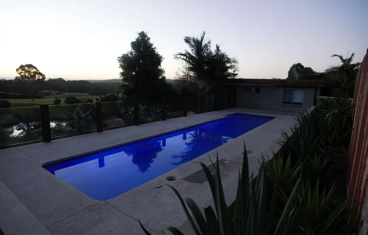 Long Masterbuilt lap pool in a backyard at dusk